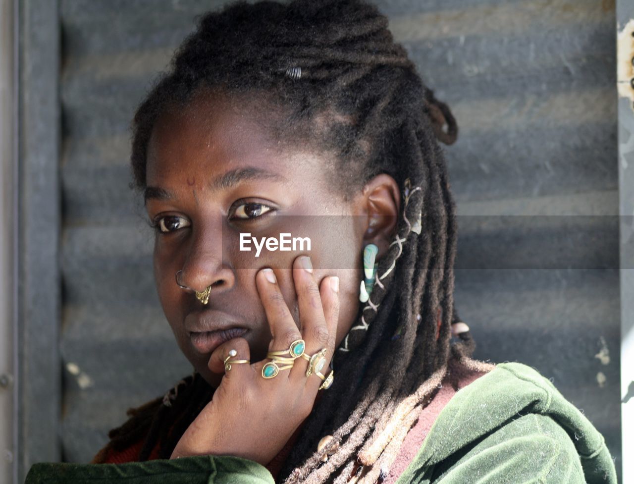 Close-up of woman with hand on cheek looking away