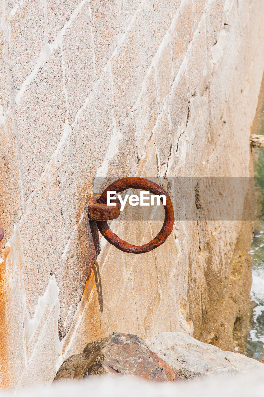 HIGH ANGLE VIEW OF RUSTY METAL HANGING ON WALL