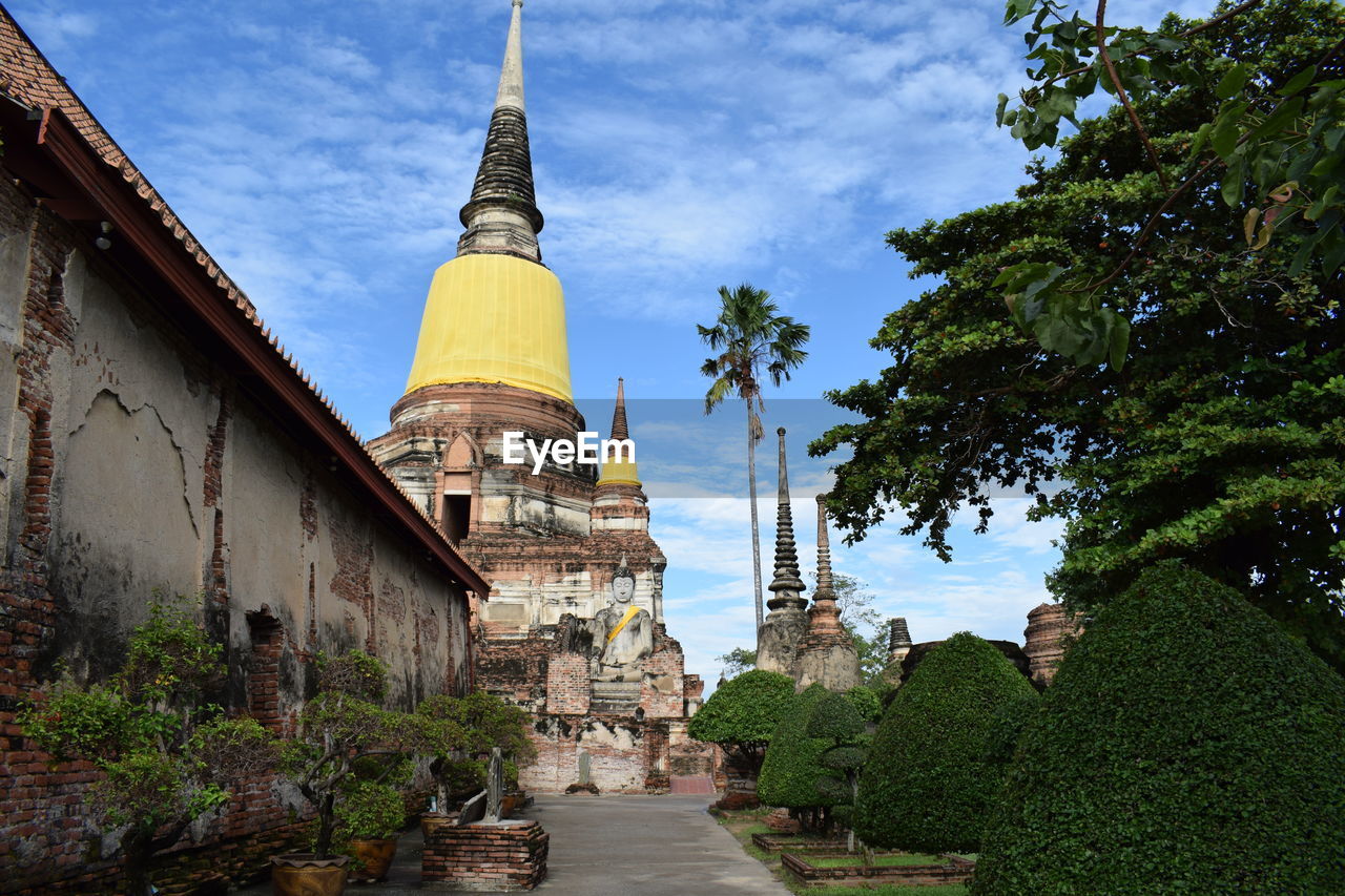 Pagoda and buddha statue against sky