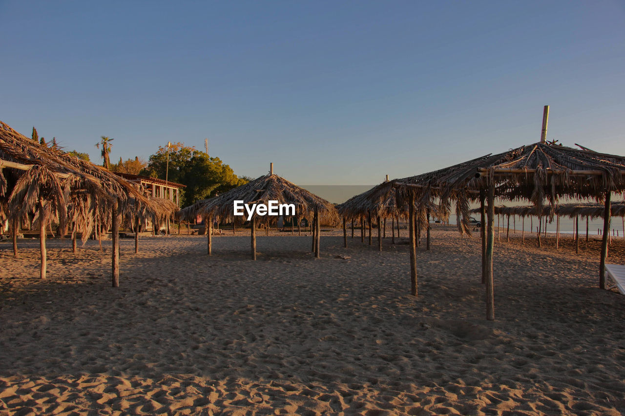 scenic view of beach against clear sky during sunset