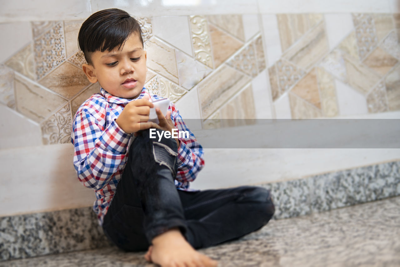 FULL LENGTH OF A GIRL SITTING ON MAN HOLDING A BABY