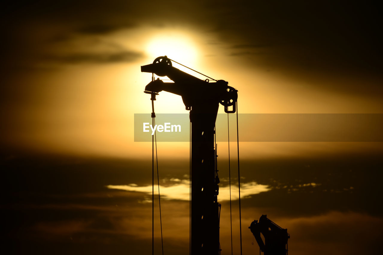 SILHOUETTE CRANES AGAINST SKY DURING SUNSET