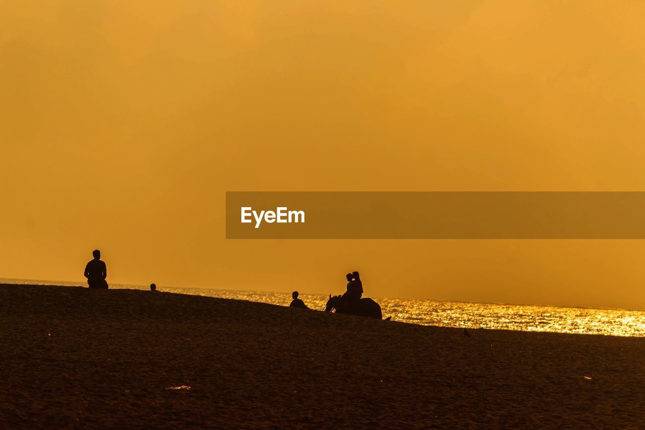 SILHOUETTE PEOPLE ON BEACH DURING SUNSET