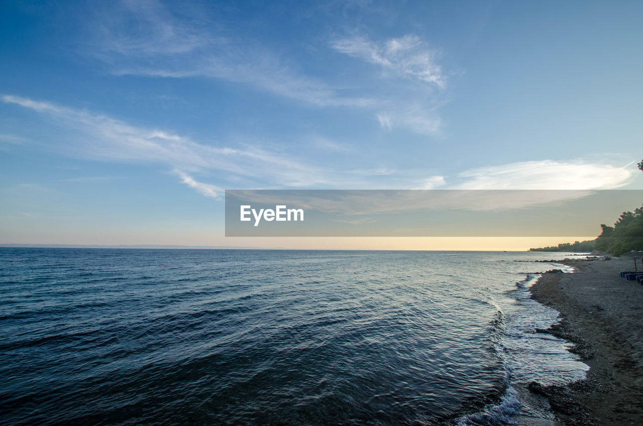 SCENIC VIEW OF BEACH AGAINST SKY DURING SUNSET