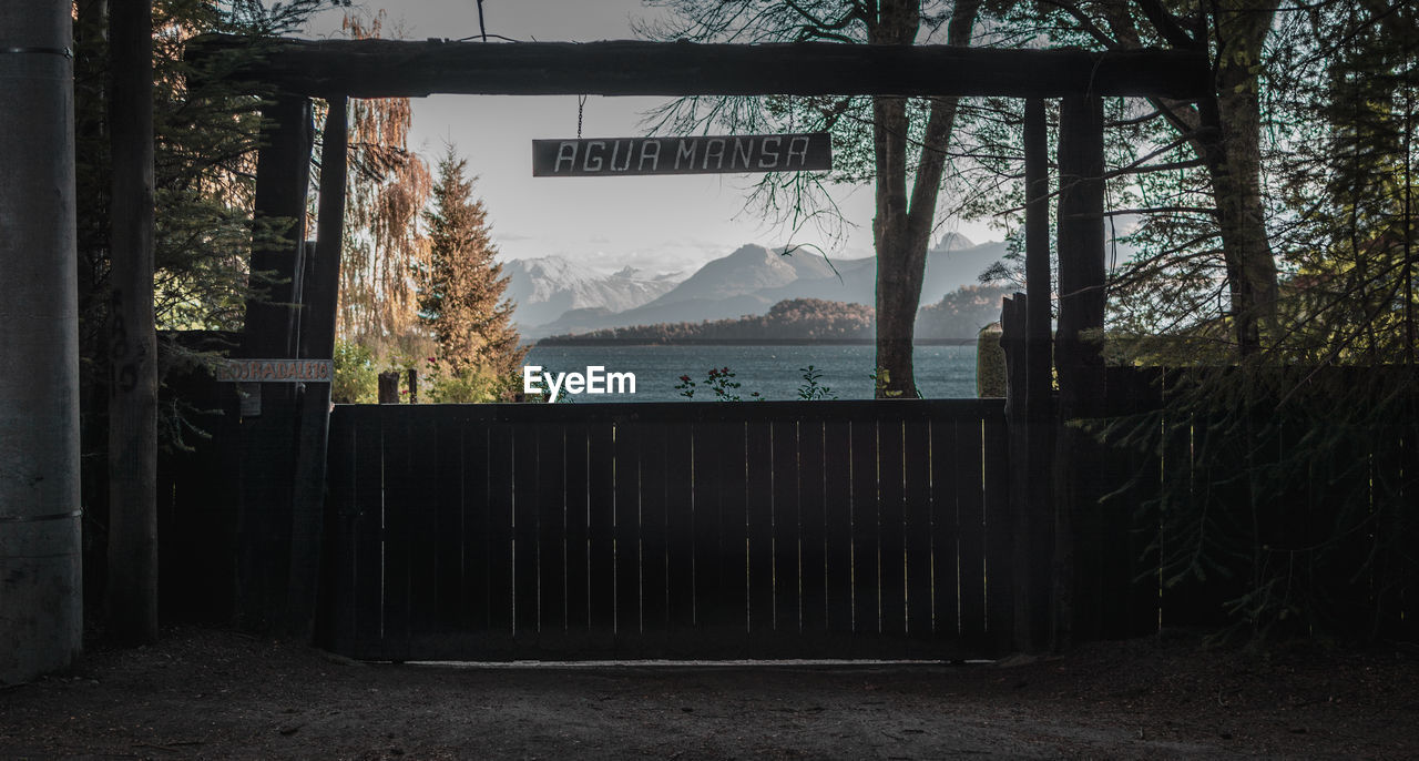 Text hanging at lakeshore against mountains