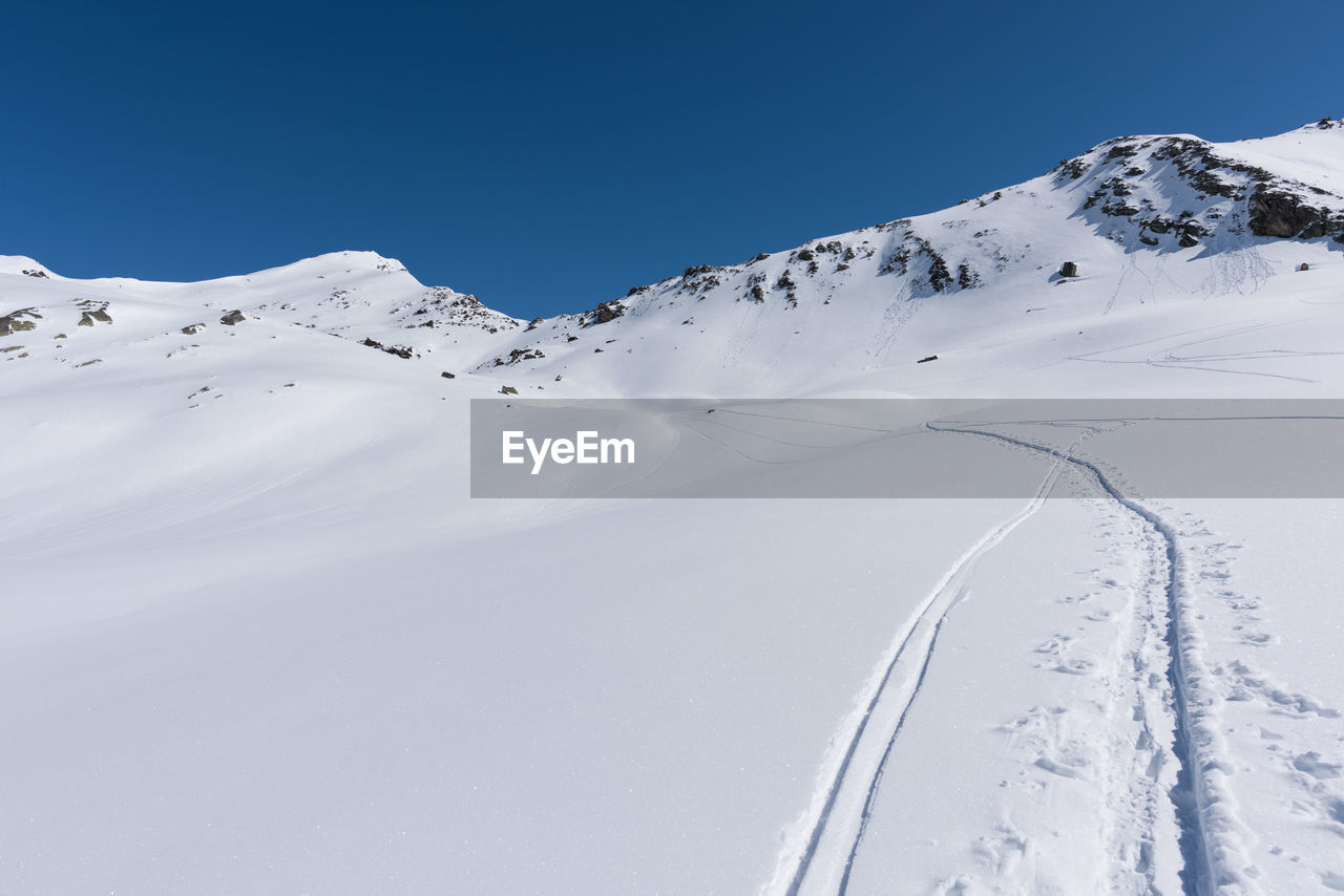 Snow covered mountain against blue sky