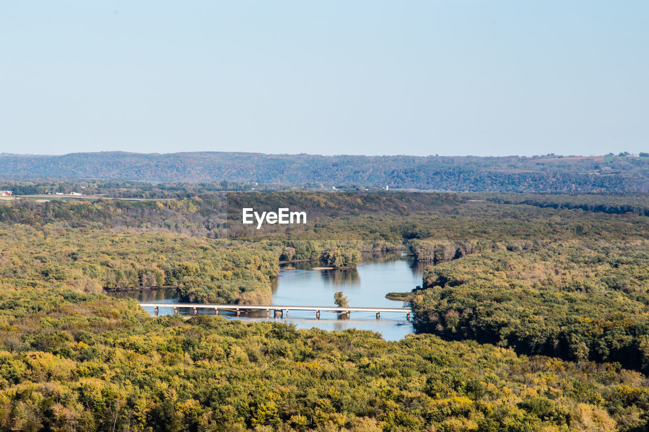 Scenic view of lake amidst tree covered landscape against sky