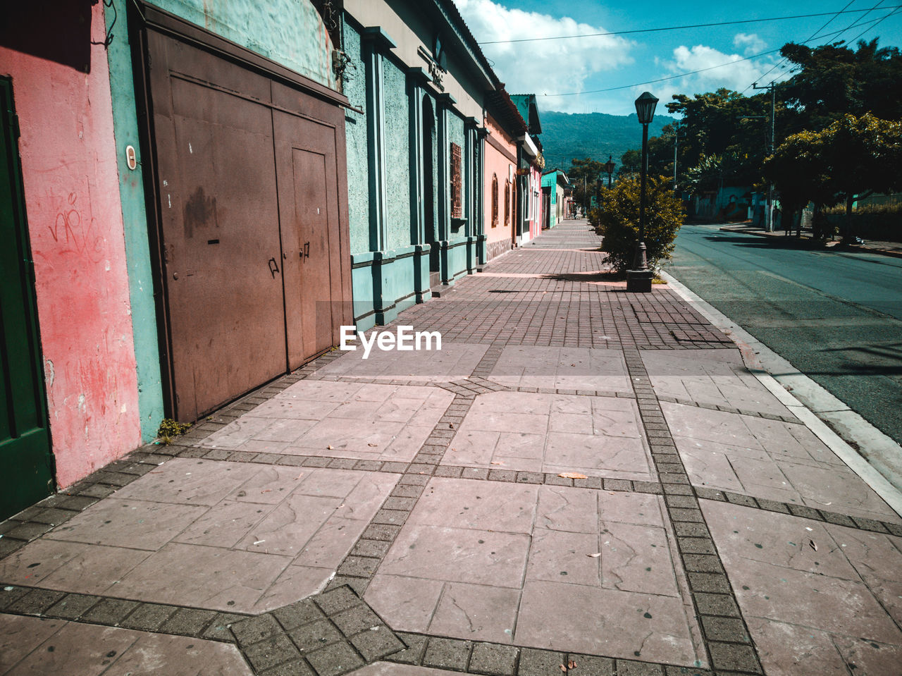 Footpath amidst buildings against sky in city