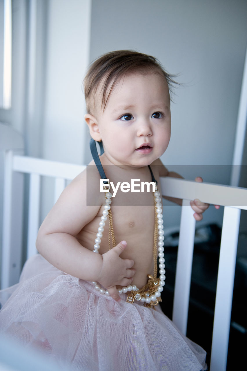 Close-up of cute shirtless baby girl wearing jewelries