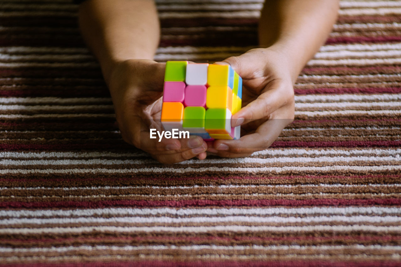 Person playing with toy cube