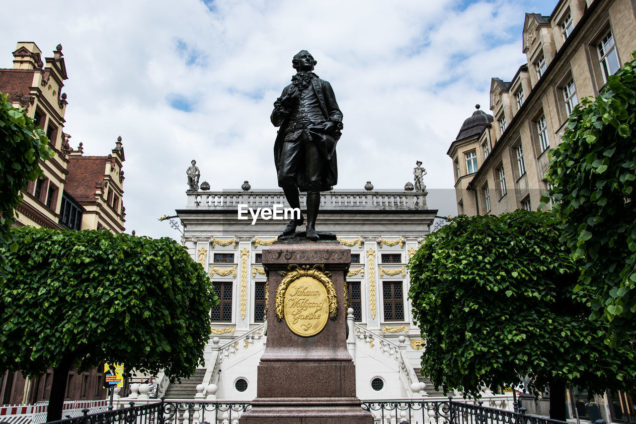 Low angle view of statue against building in city