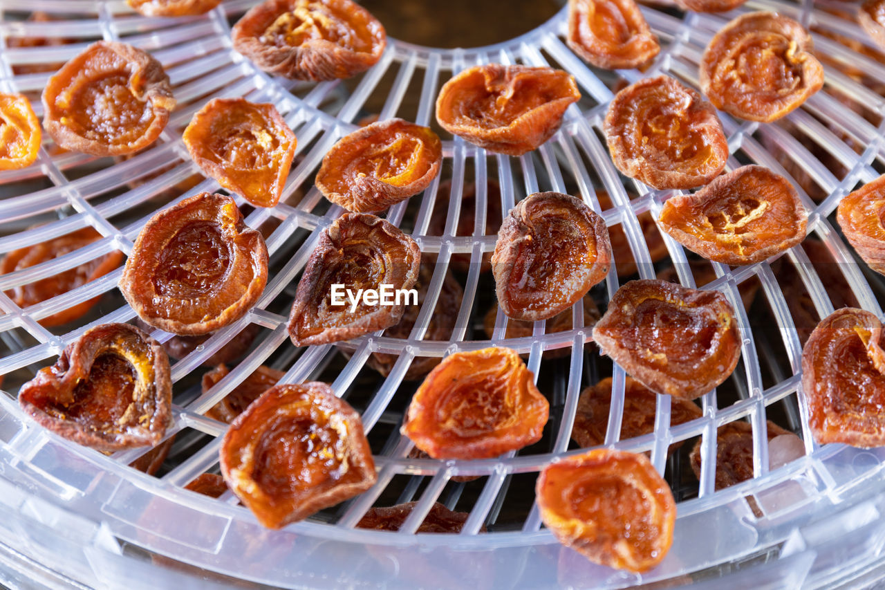 The process of home cooking dried fruits or candied fruit in an electric dryer on a rustic table. 