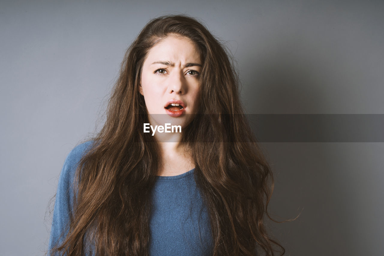 Stunned shocked young woman is taken aback and left speechless with open mouth