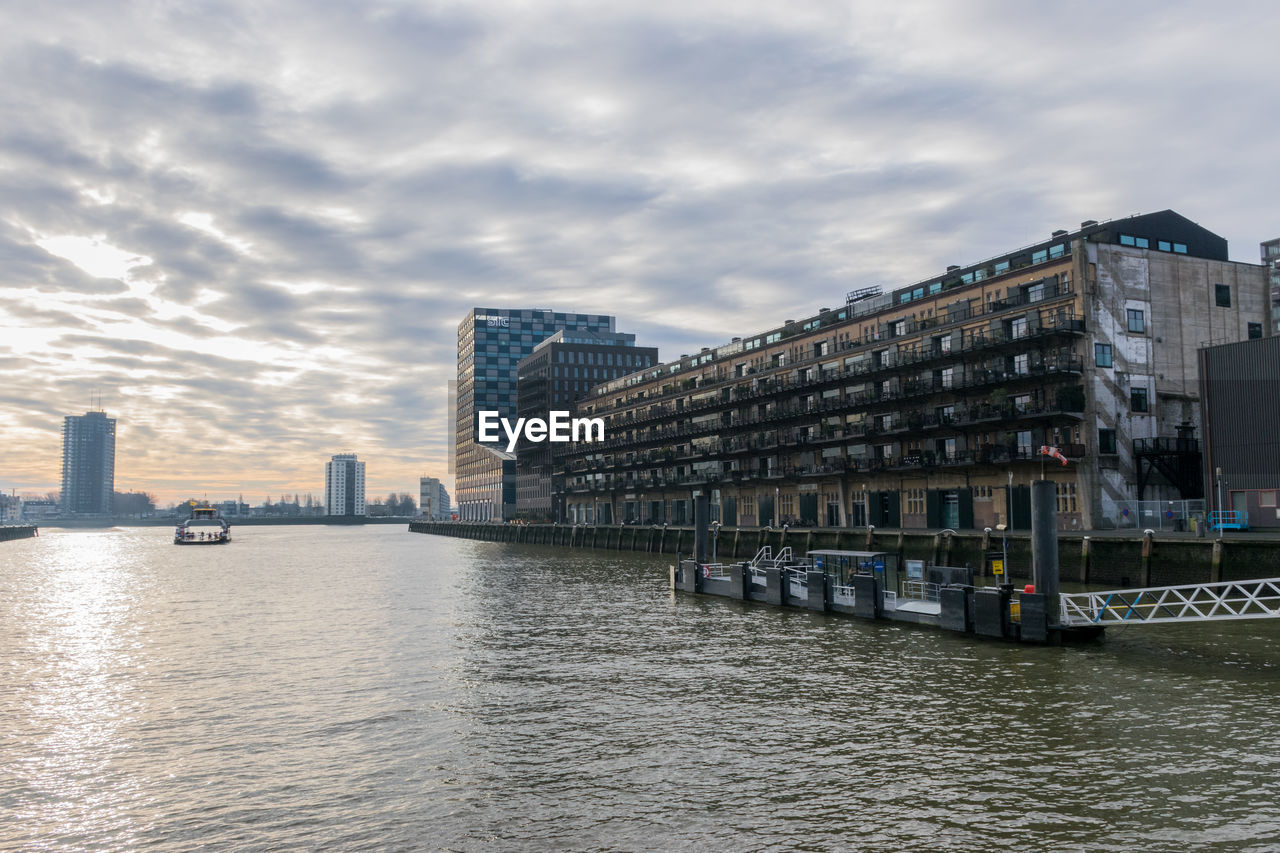 River by buildings against sky in city of rotterdam