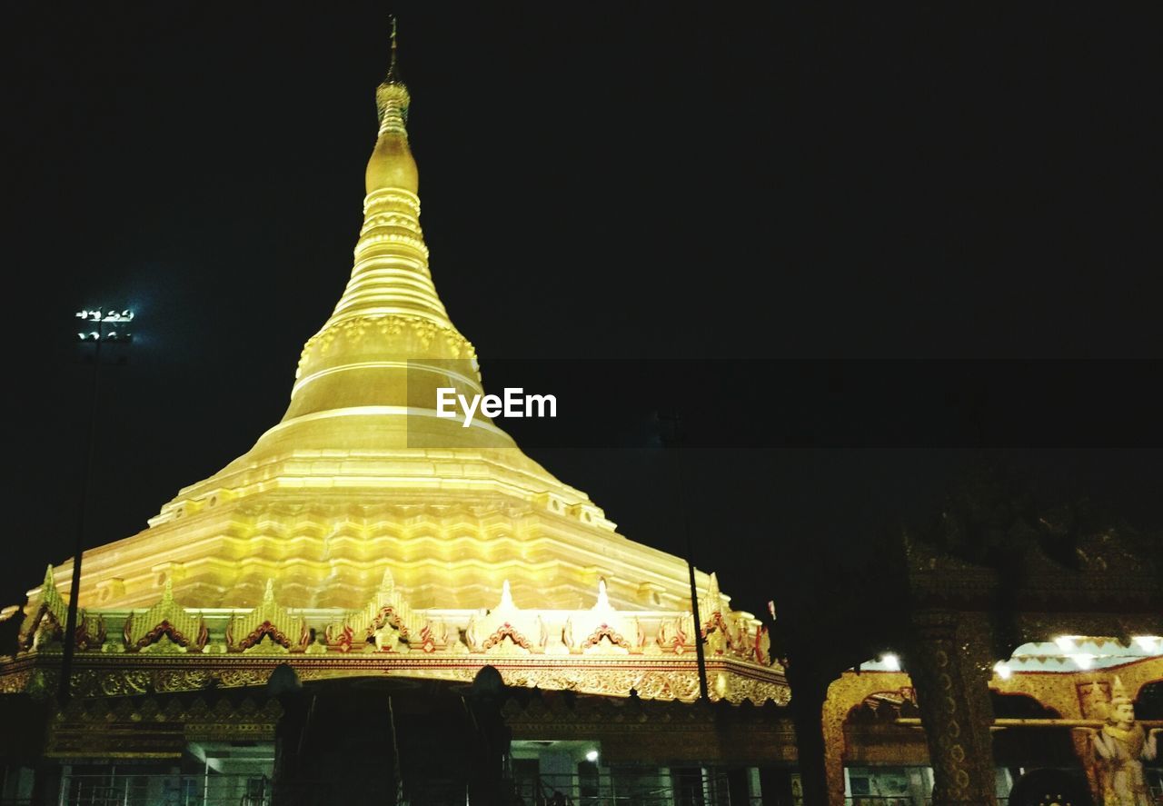 LOW ANGLE VIEW OF ILLUMINATED TEMPLE