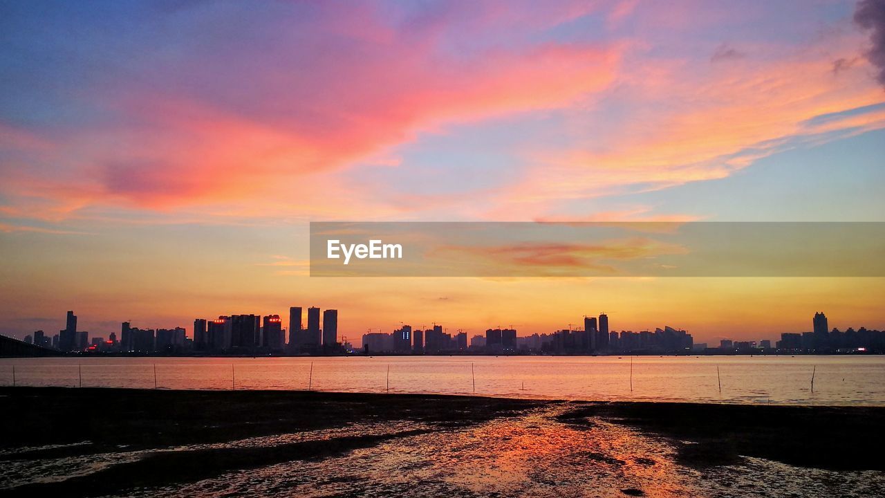 SILHOUETTE CITYSCAPE AGAINST SKY DURING SUNSET