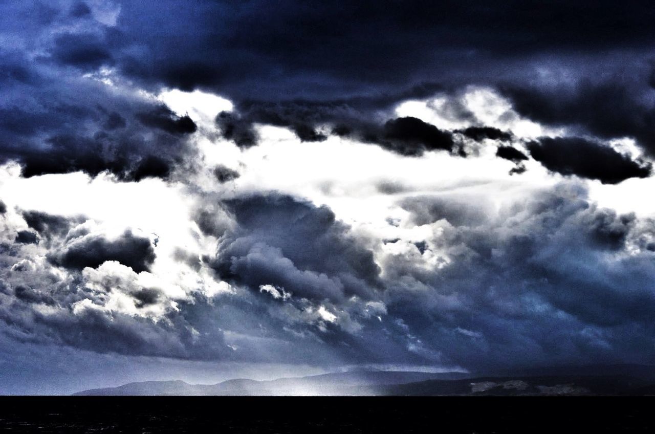 Black cloudy sky over mountain