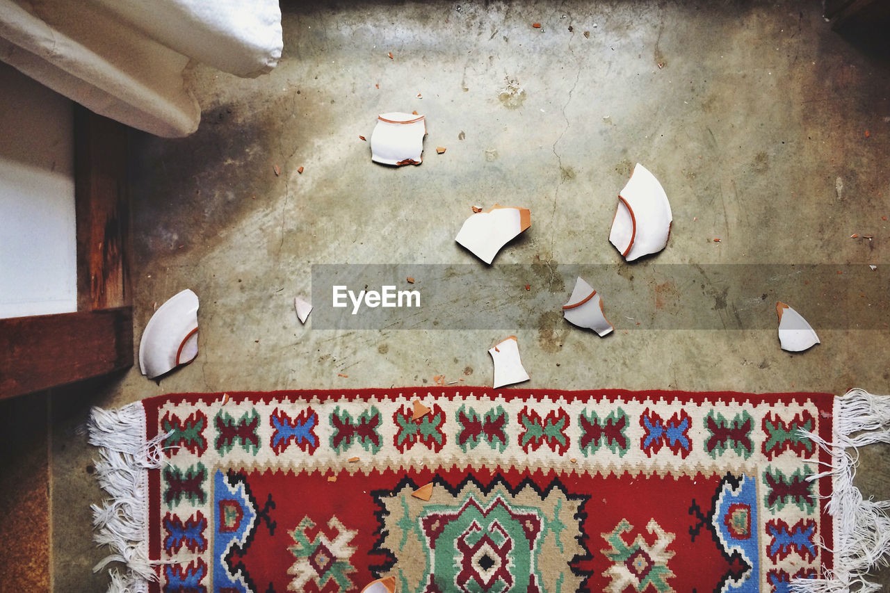 Directly above shot of broken plate by carpet at home