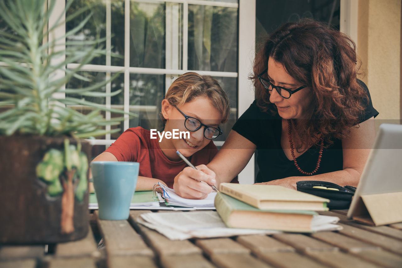 Mother assisting son in homework at home