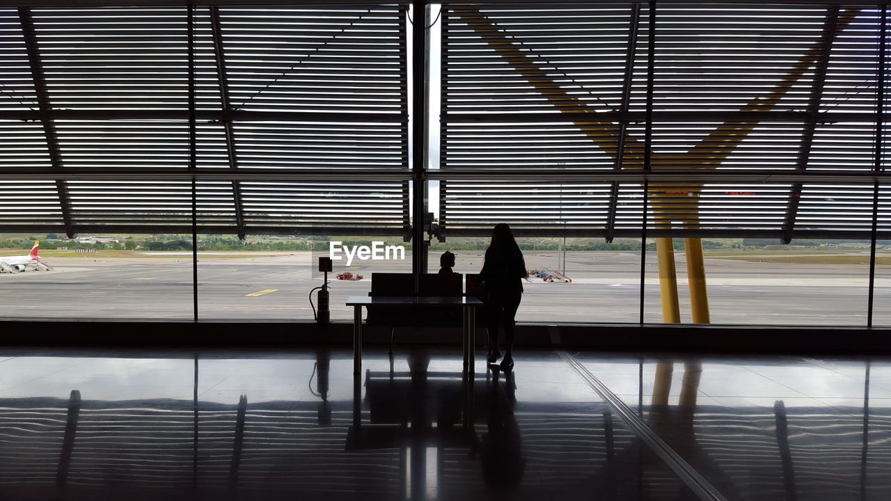 SILHOUETTE PEOPLE SITTING ON AIRPORT