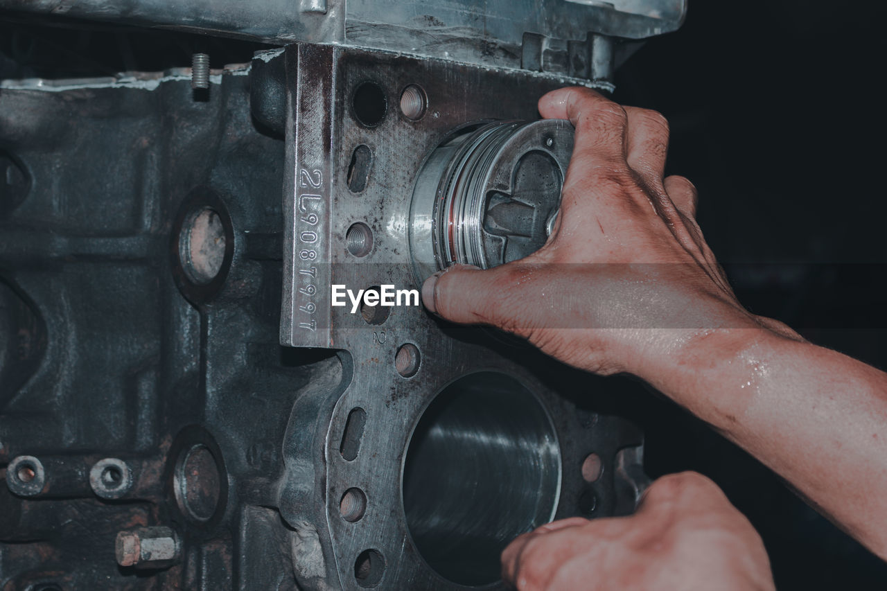 hand, one person, automotive tire, adult, close-up, indoors, men, technology, tire, holding, engine, occupation, metal, wheel