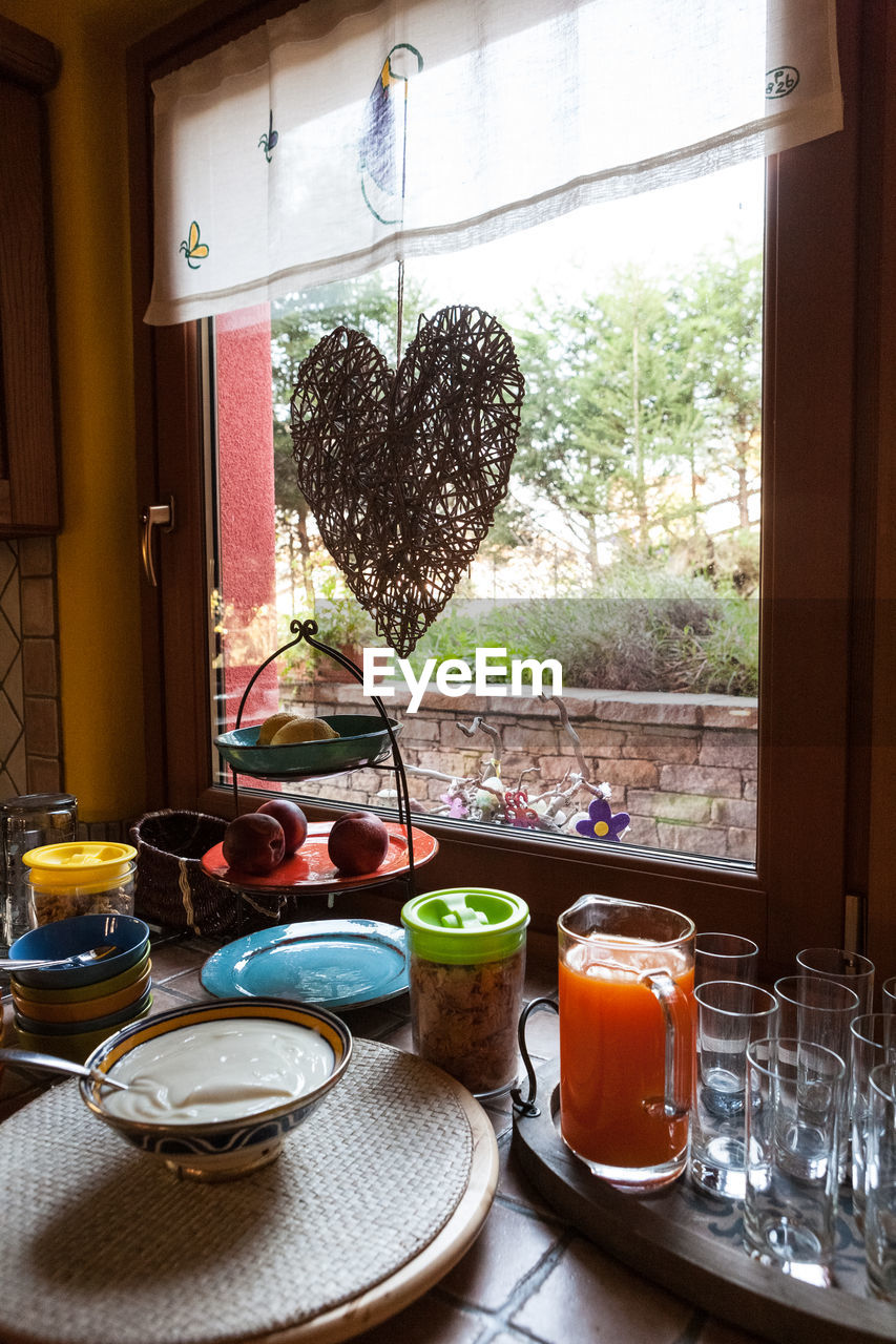 Food and drink on table by window at home