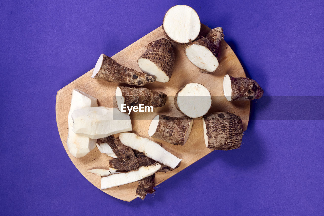 Fresh organic cassava root, manioc esculenta, yuca on purple background