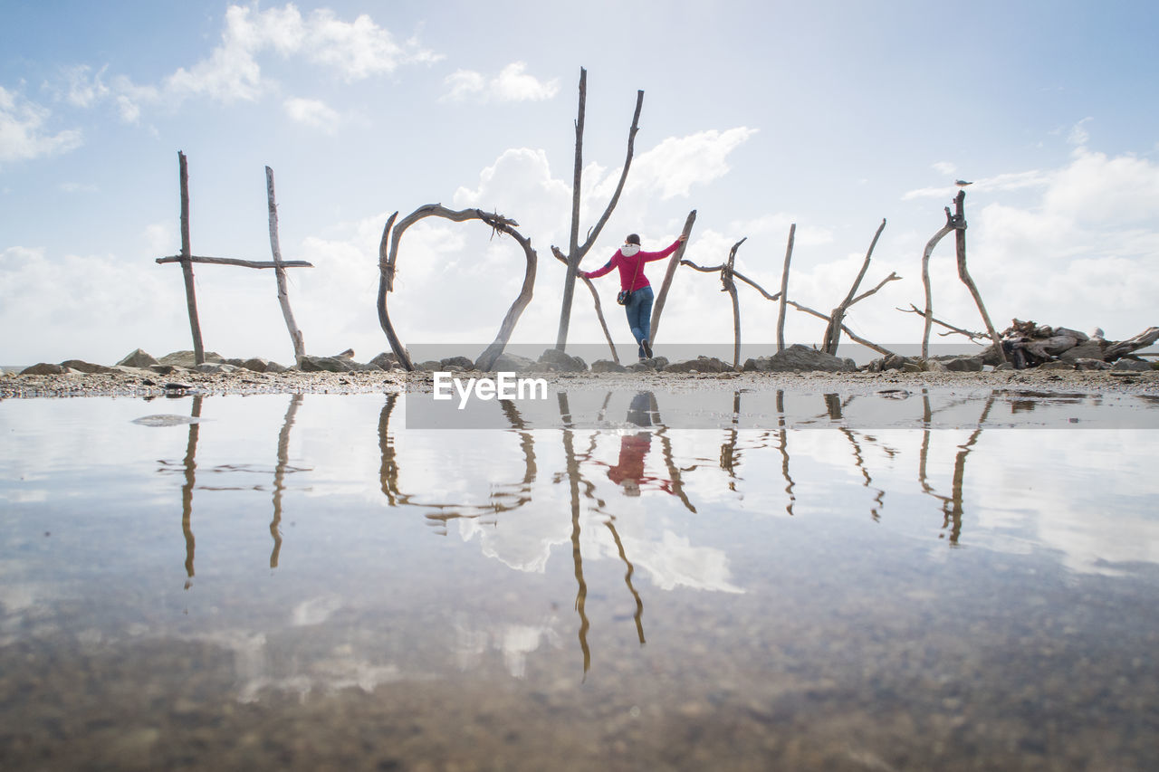 Woman standing with hokitika text at beach