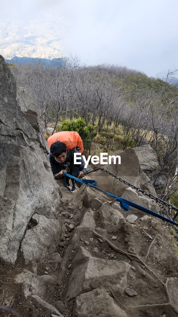 adventure, climbing, rock, activity, sports, nature, leisure activity, mountain, rock climbing, extreme sports, adult, challenge, full length, recreation, rope, determination, one person, risk, sign, day, men, protection, warning sign, land, communication, outdoors, strength, mountaineering, rock formation, ridge, safety harness, helmet, sky, environment, mountain climbing, skill, headwear, geology, lifestyles, landscape, mature adult, cloud, sports helmet, scenics - nature, vitality, mountain range