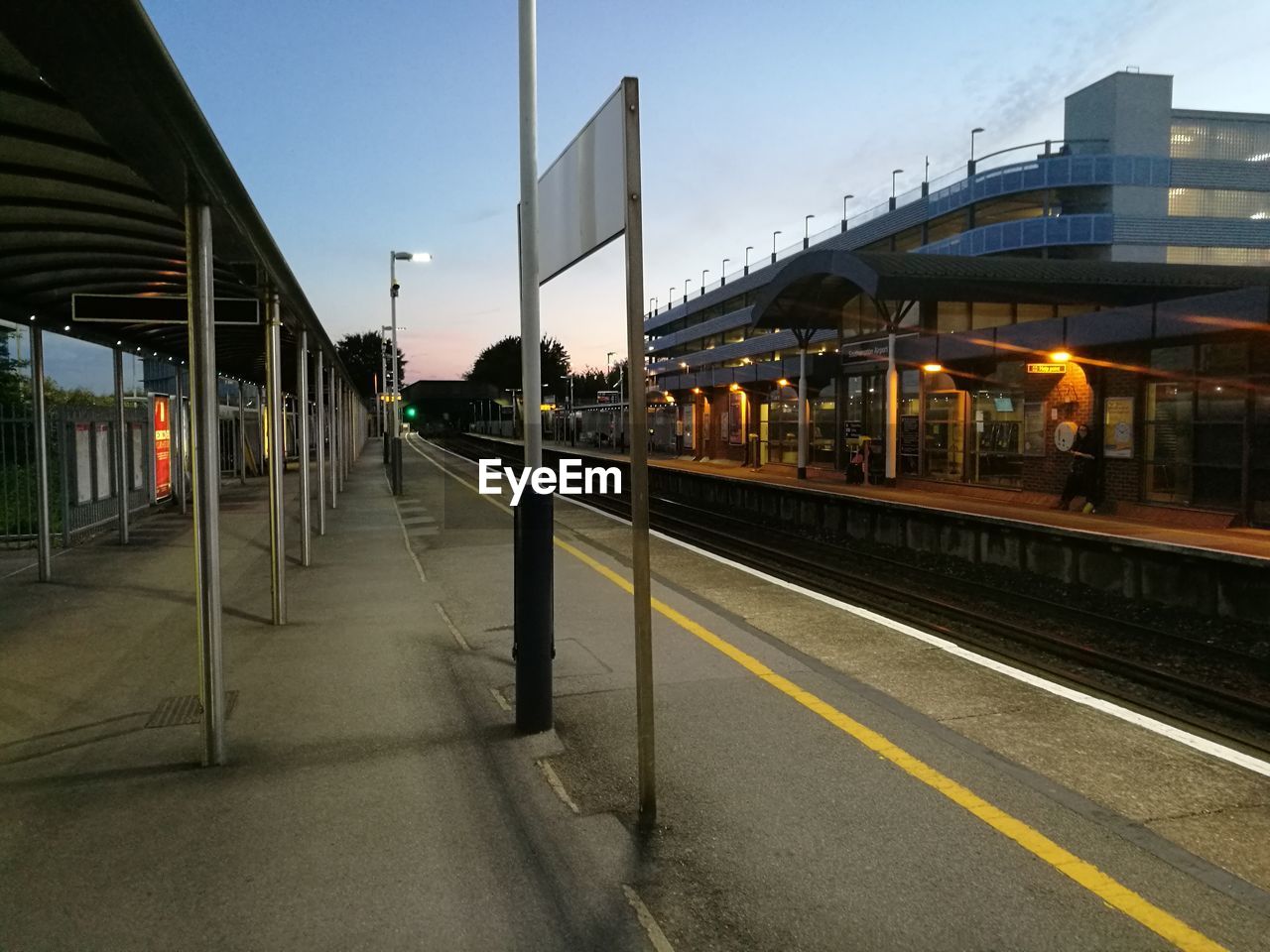 Empty railroad station in city against sky