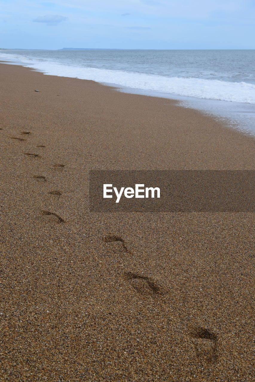 FOOTPRINTS ON SAND AT BEACH