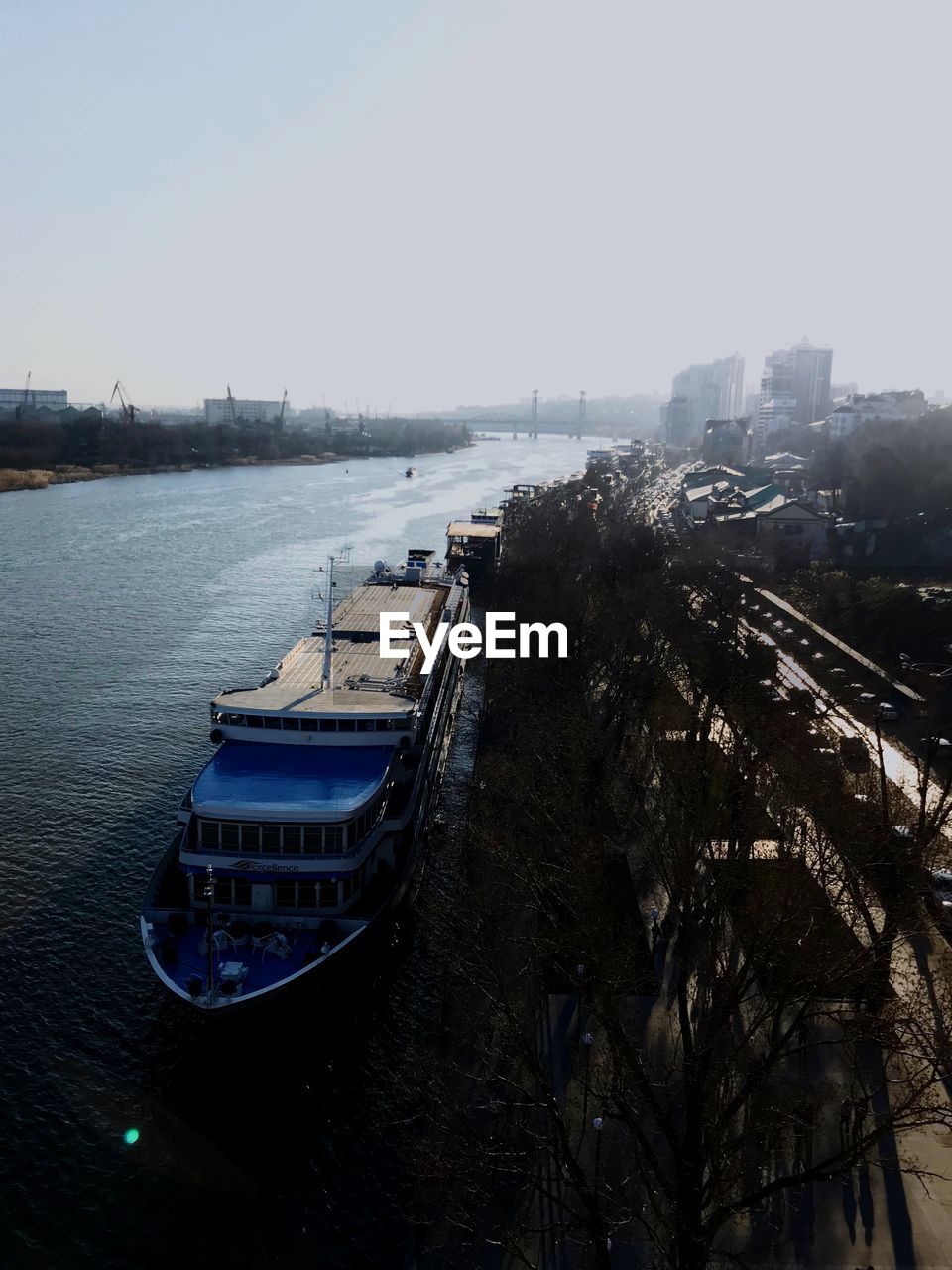 HIGH ANGLE VIEW OF RIVER BY CITY AGAINST CLEAR SKY