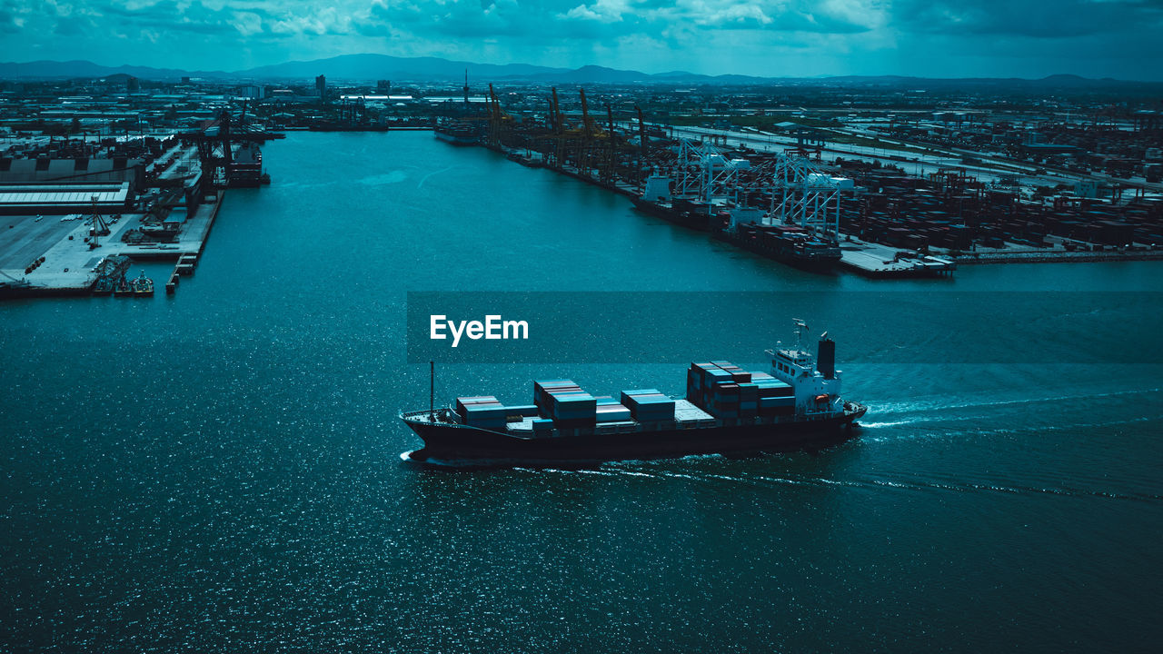 High angle view of shipping container sailing in sea and shipping terminal background cinematic