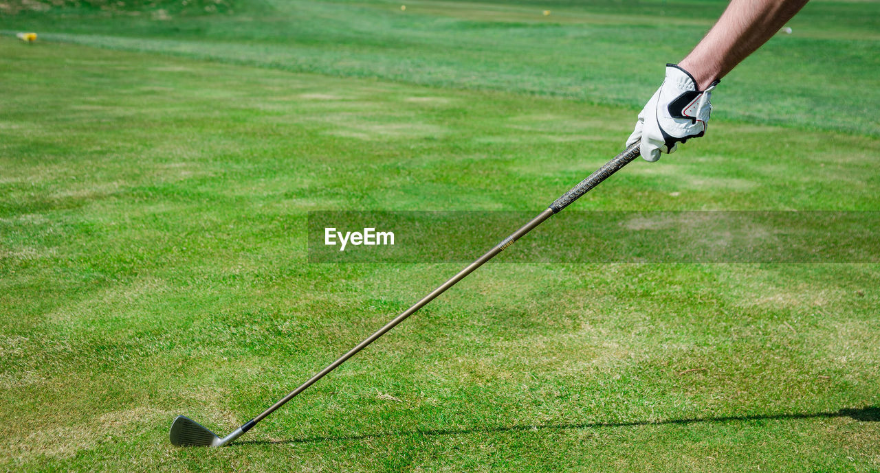 Cropped hand of man holding golf club