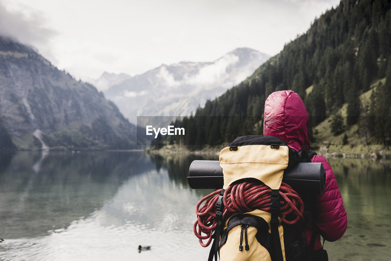 Austria, tyrol, alps, hiker standing at mountain lake