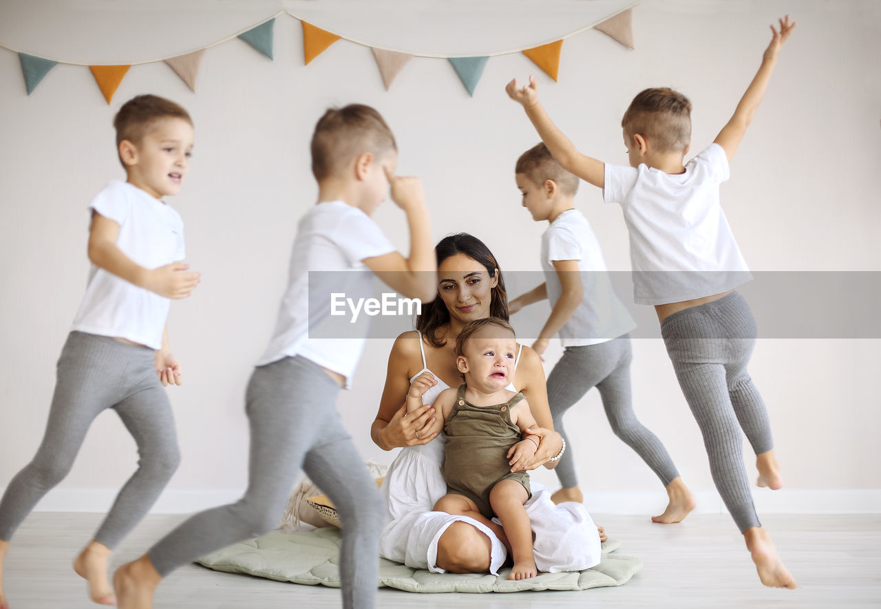 full length of family standing on floor at home