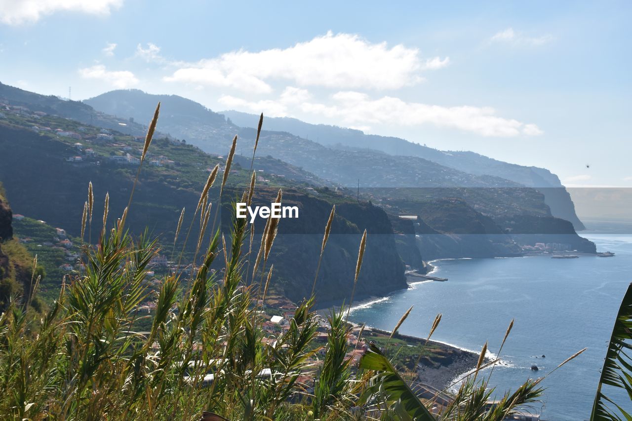 SCENIC VIEW OF SEA AGAINST MOUNTAINS