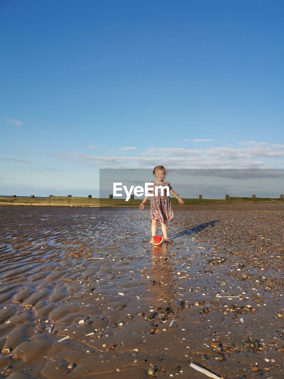 Front view of child on beach against sky