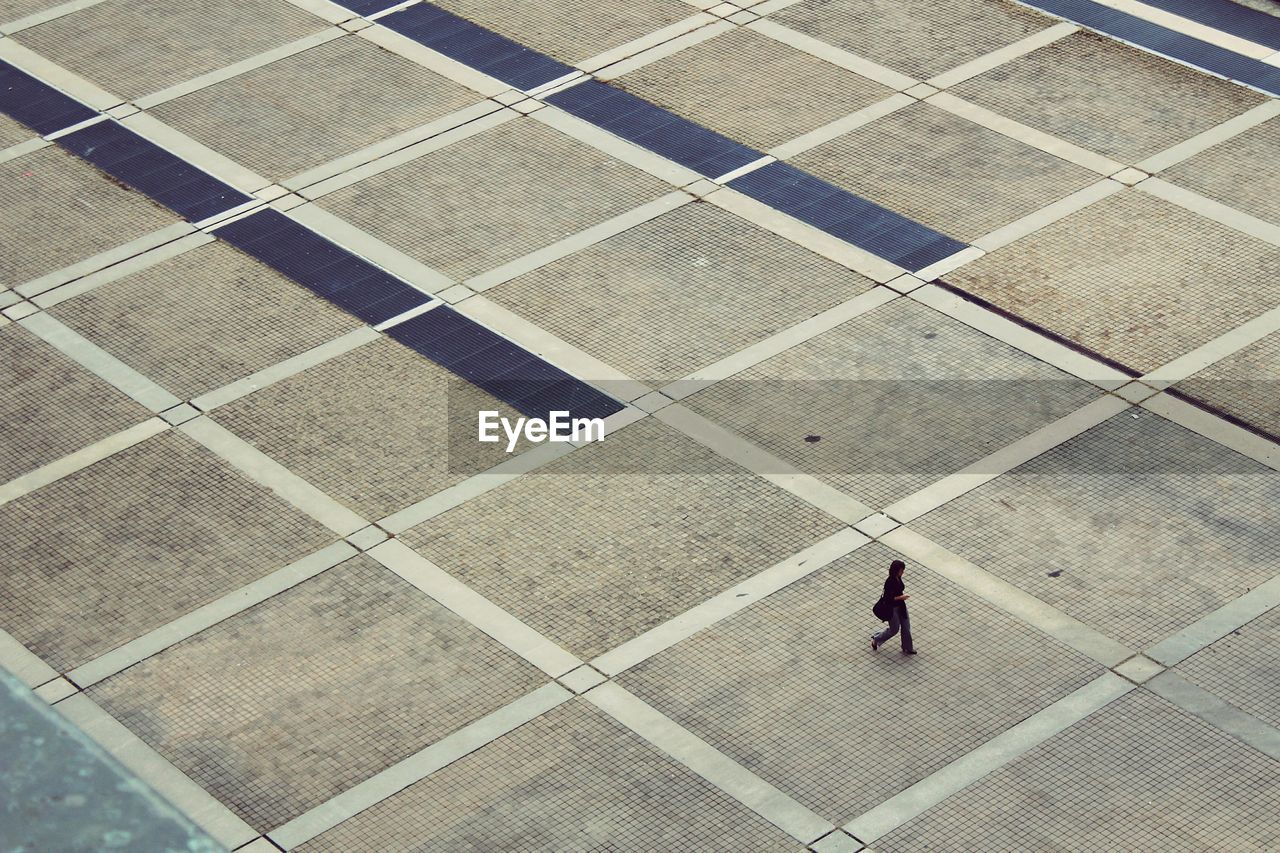 High angle view of woman walking on pavement