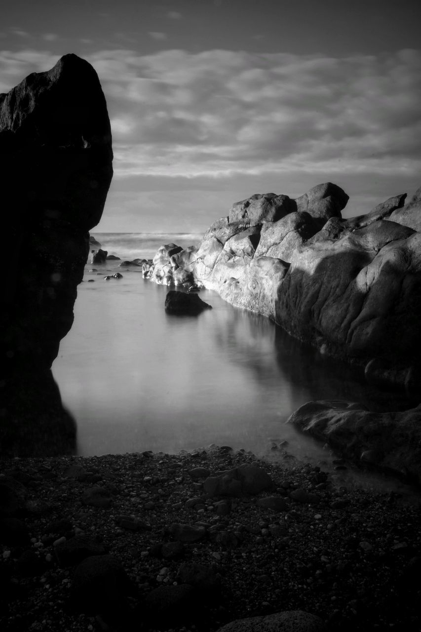 Rock formations by sea against sky