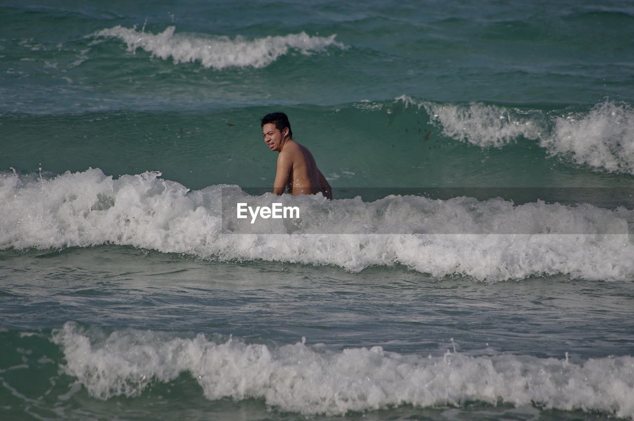 MAN STANDING IN SEA