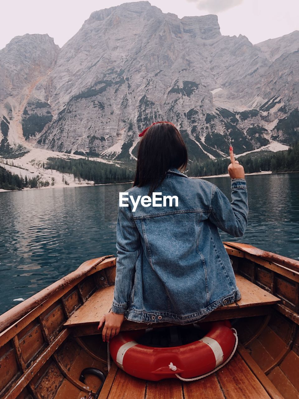 rear view of woman looking at lake against mountains