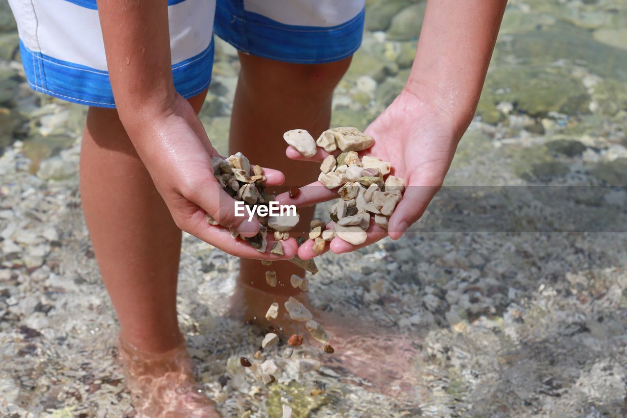 High angle view of person searching stones in river