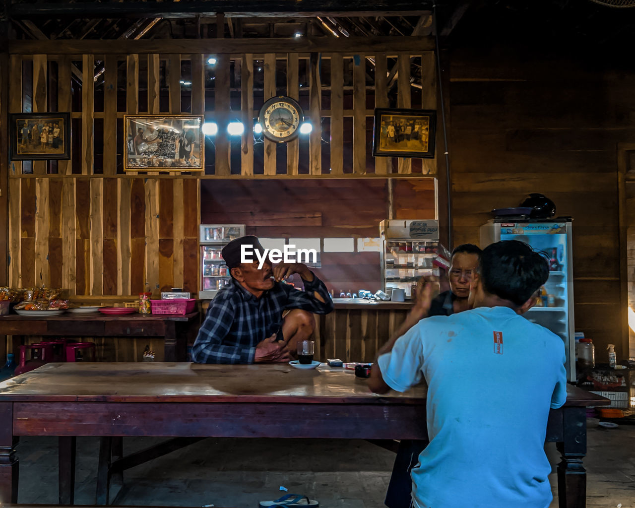 MAN WORKING IN ILLUMINATED RESTAURANT