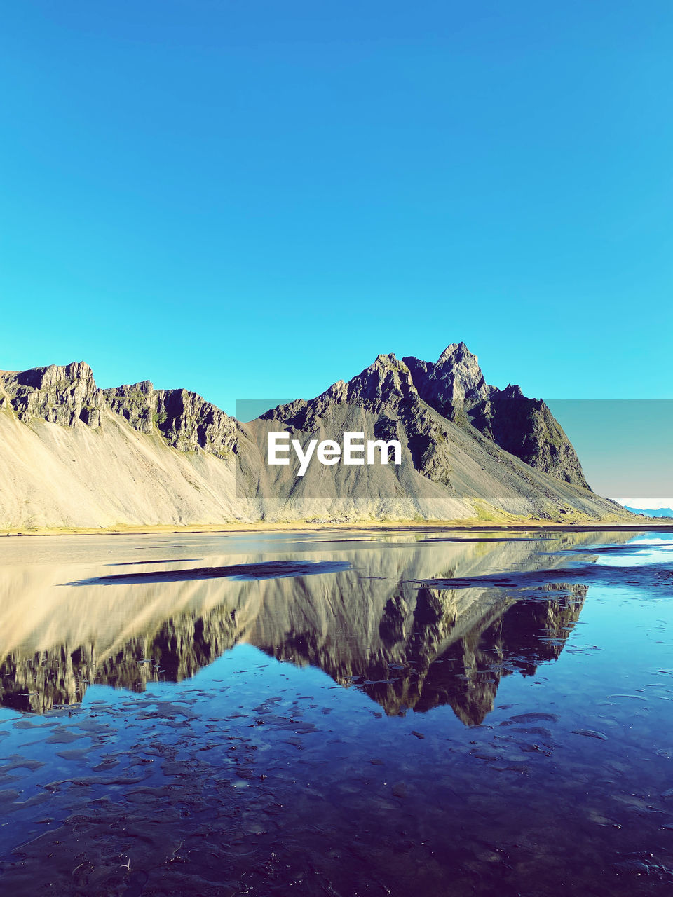 water, reflection, scenics - nature, sky, beauty in nature, blue, landscape, mountain, nature, environment, lake, tranquility, tranquil scene, clear sky, horizon, no people, cold temperature, non-urban scene, travel destinations, snow, day, land, travel, mountain range, copy space, winter, outdoors, dawn, lagoon, idyllic, morning, plateau, remote