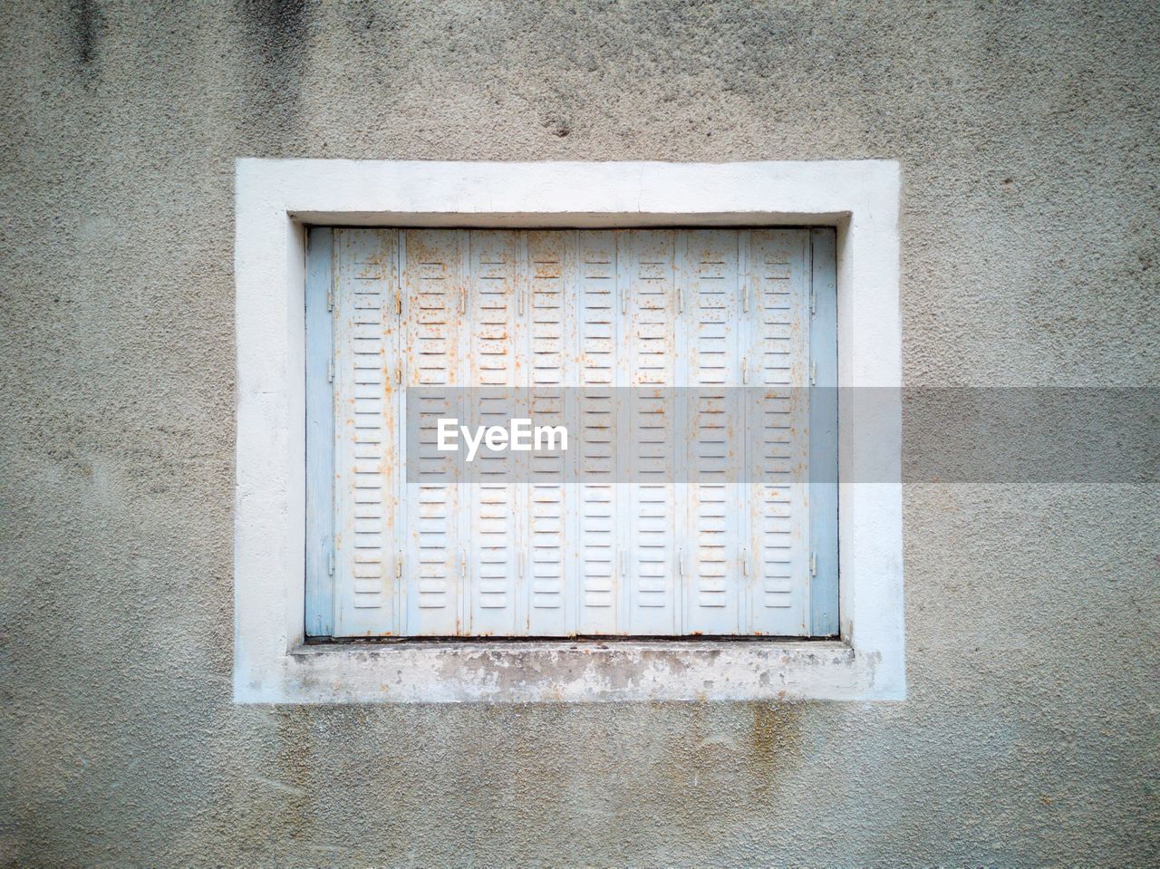 Close-up of white metal window on building wall