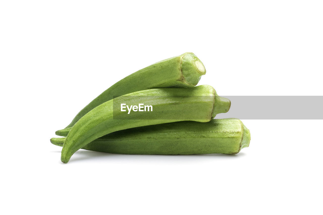 CLOSE-UP OF GREEN CHILI PEPPER AGAINST WHITE BACKGROUND