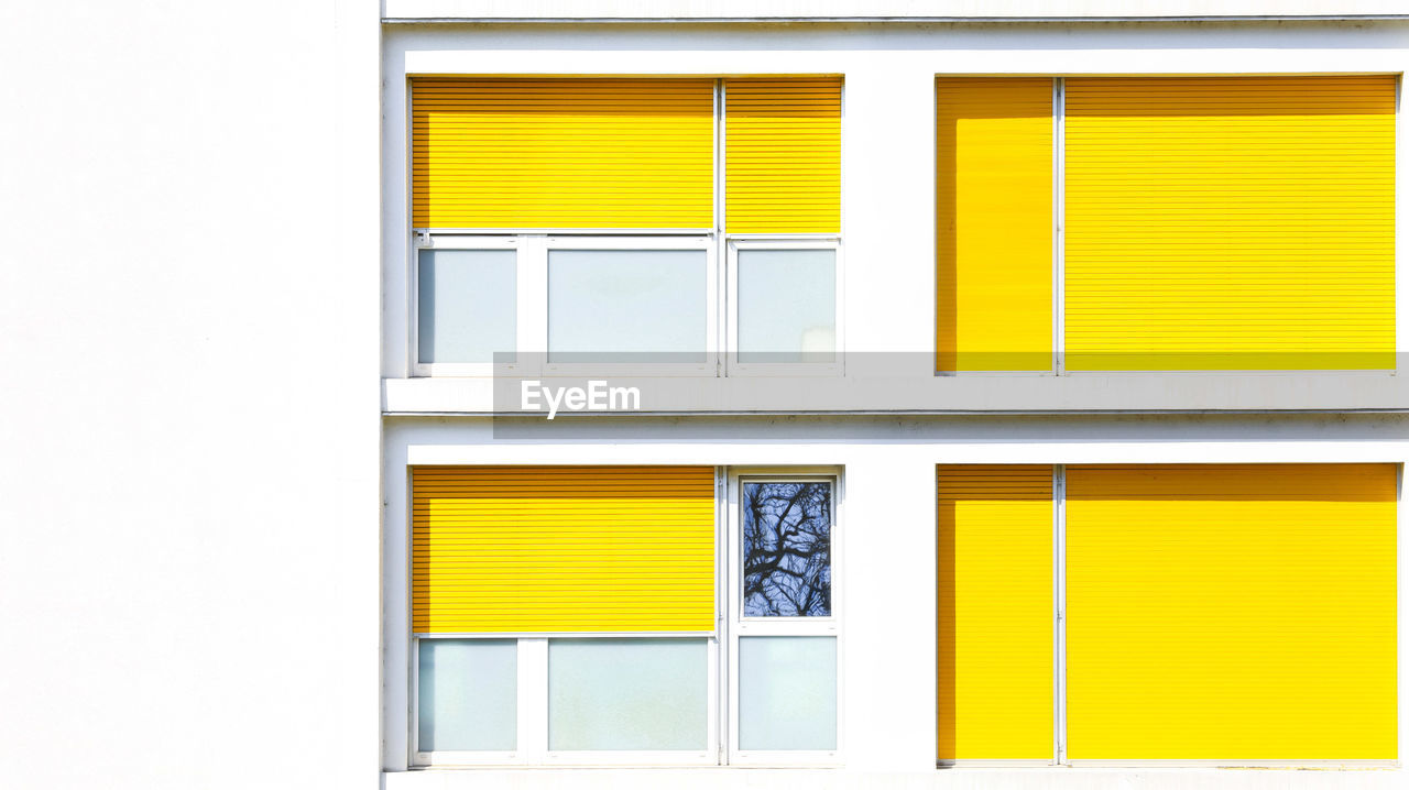 Full frame shot of yellow building and windows 