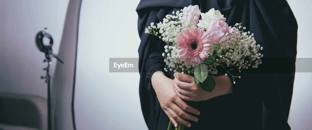 WOMAN HOLDING FLOWER BOUQUET