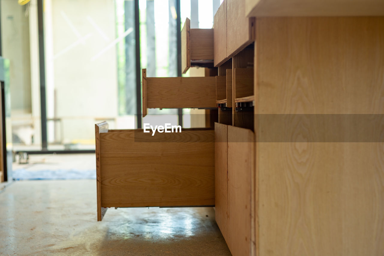 Opening wooden shelves under installation inside the house under construction